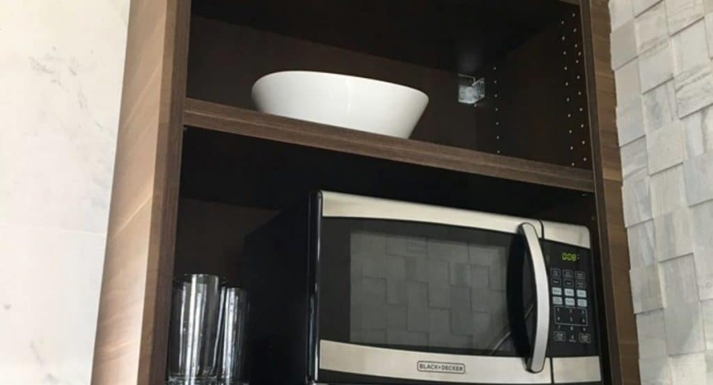 Microwave in dark wood cabinet