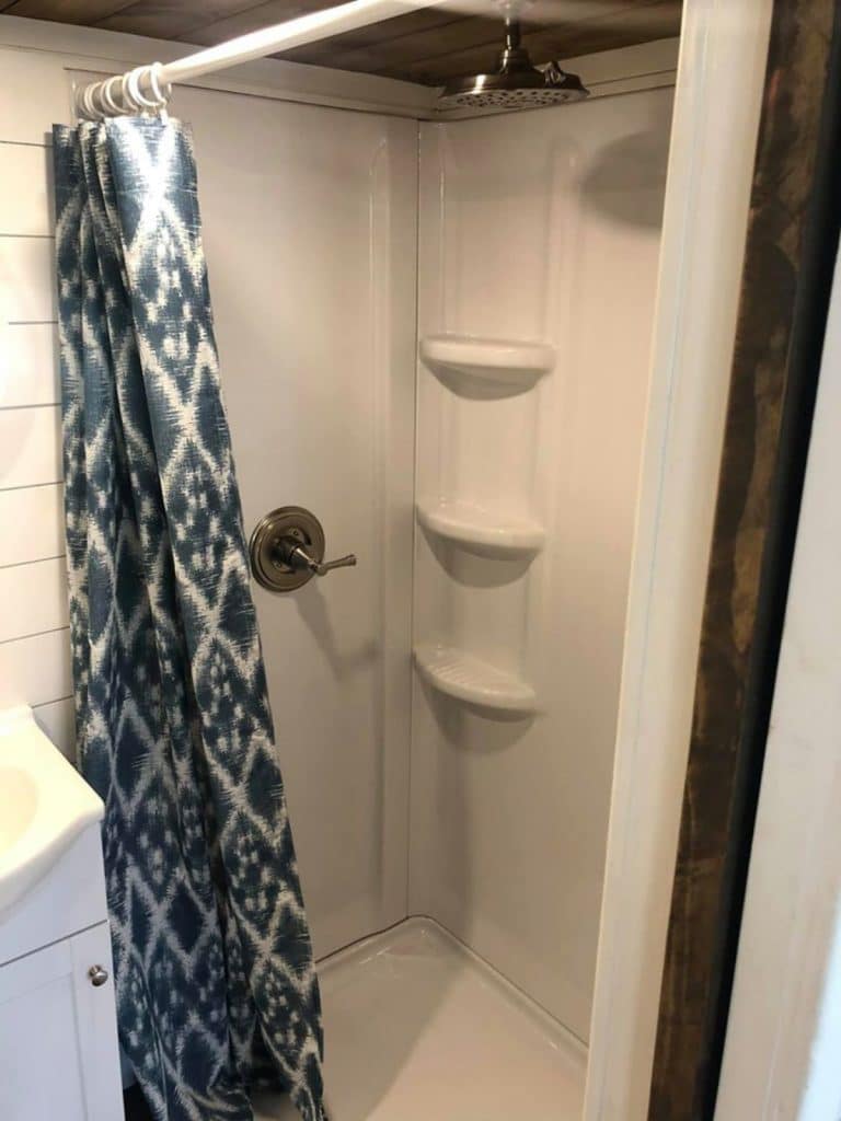 White shower stall with blue curtain