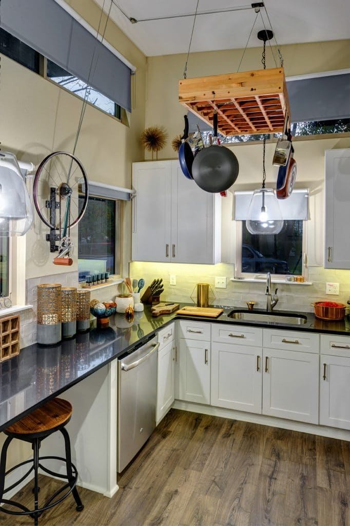 Kitchen with white cabinets and hanging pans