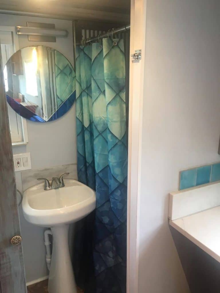 Tiny house shower with teal curtain