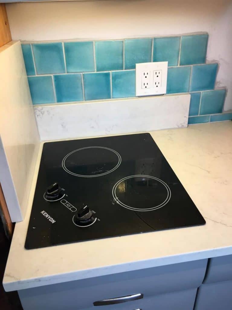 Stovetop in tiny house with teal tile