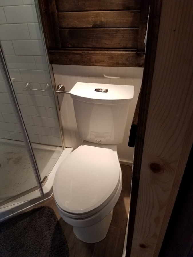 Toilet by shower in tiny house