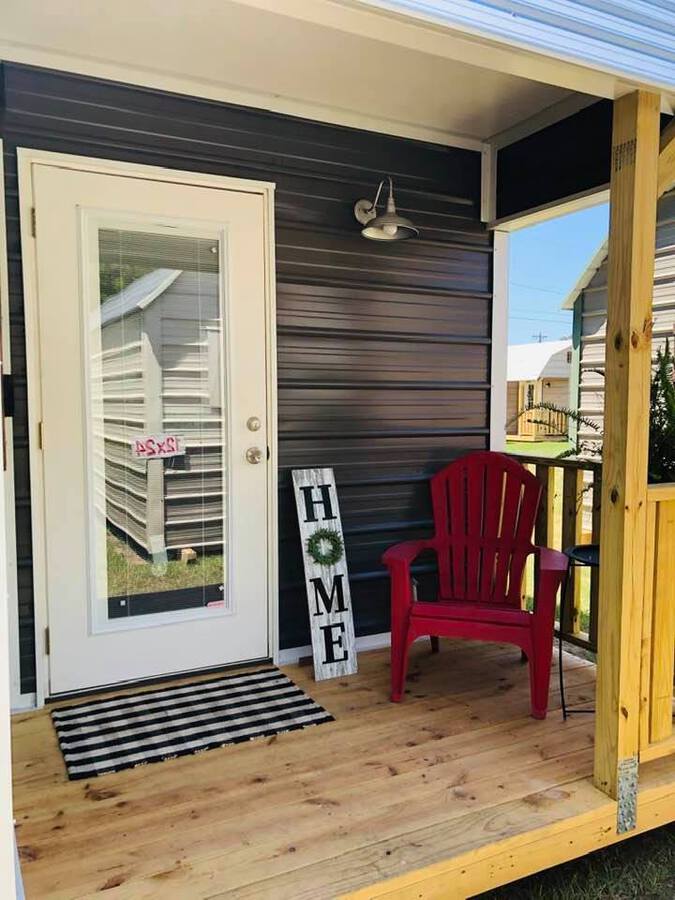 Front porch with red chair and home sign