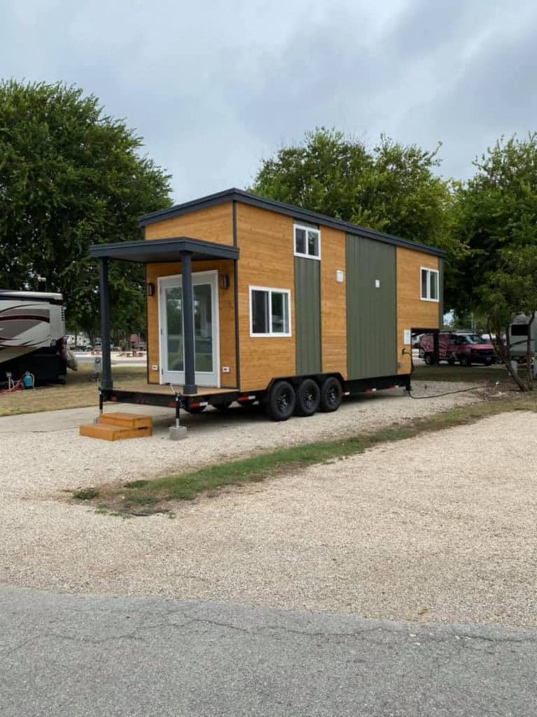 Brown and green tiny house with porch