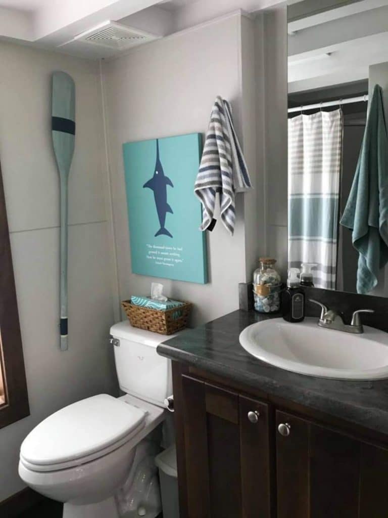 Bathroom with teal accents and oar on wall