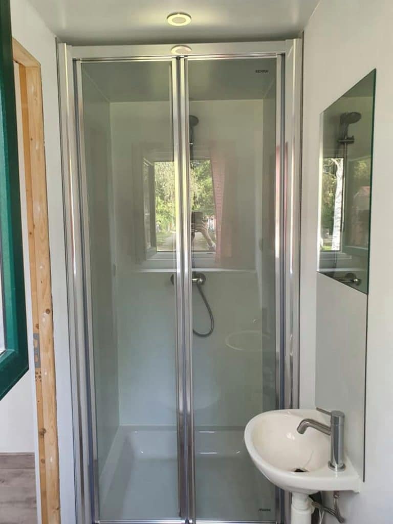 Shower stall with glass door in tiny house