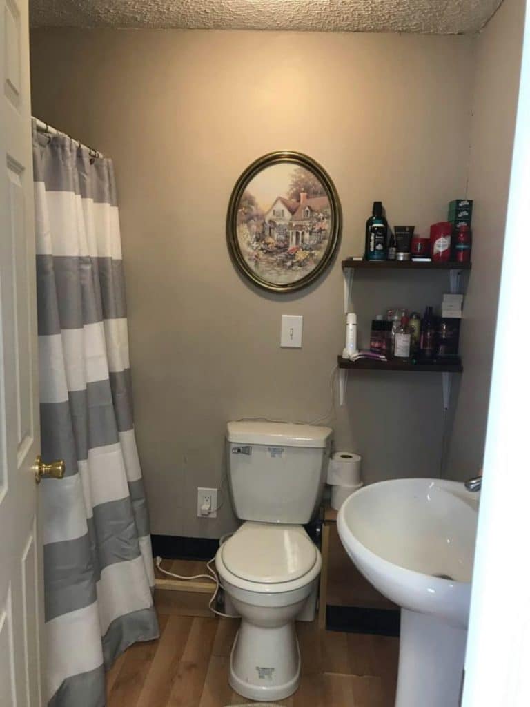 Bathroom with white toilet and sink and striped shower curtain