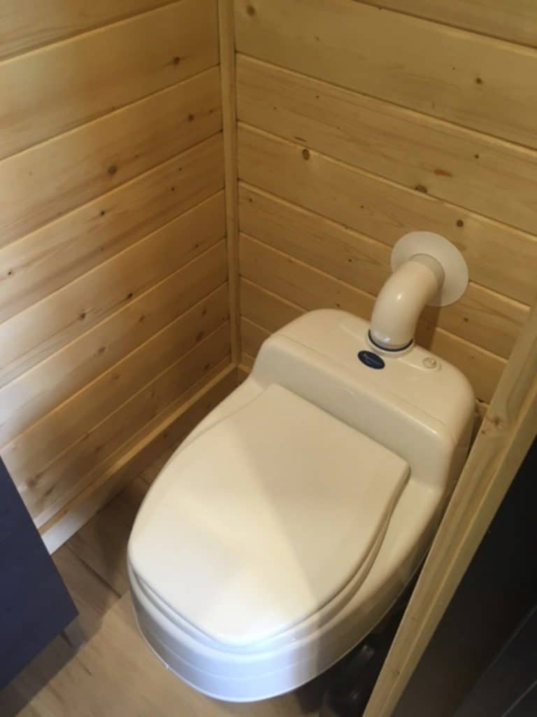 White toilet in wooden stall