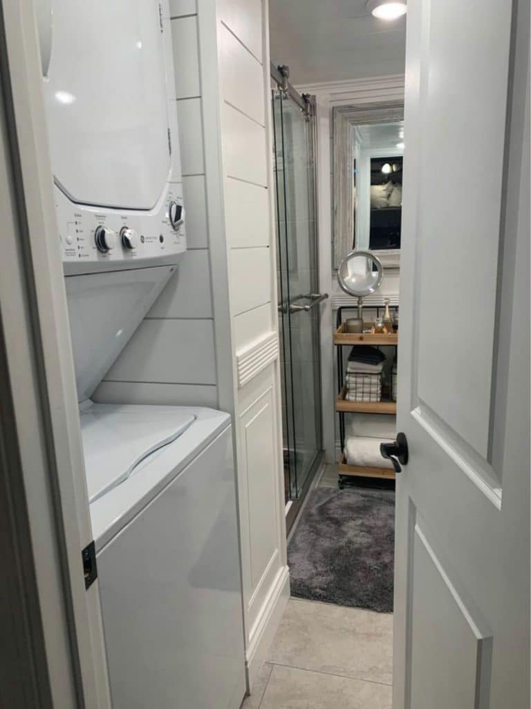 View into tiny bathroom with washer and dryer in foreground