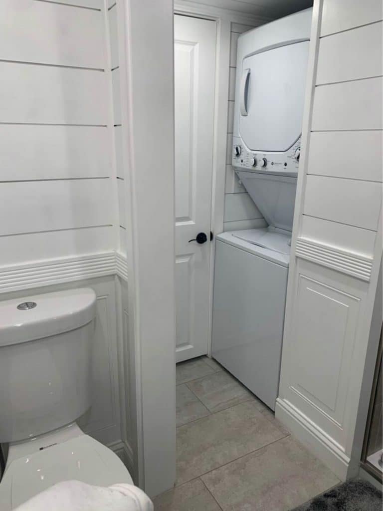 White bathroom with stacking washer and dryer