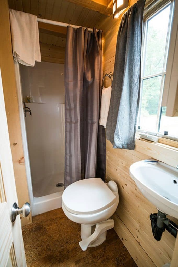 Toilet by small shower in tiny bathroom