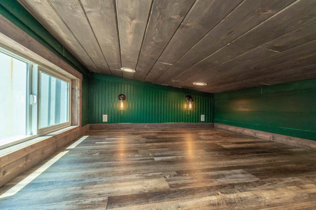 Large open loft with green walls and dark wood floor