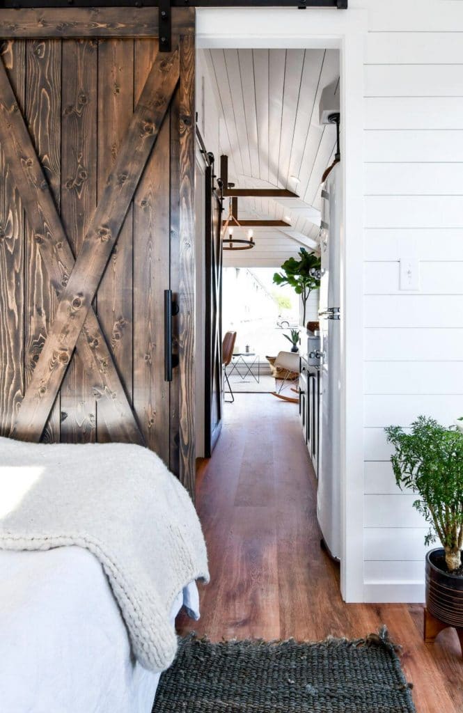 Barn door by bed with white bedding