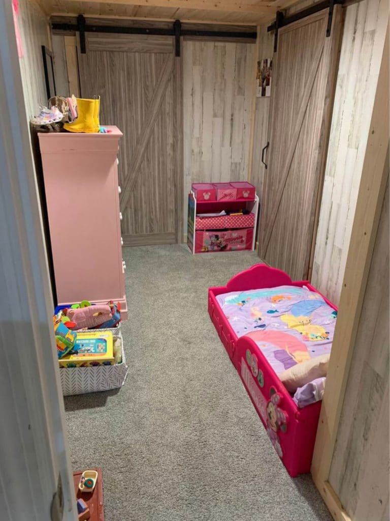 View into kids room with pink shelving and bed