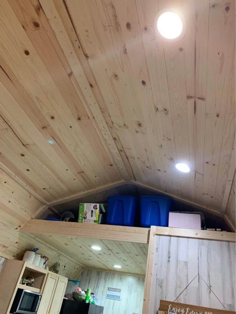 Storage loft with blue totes above kitchen