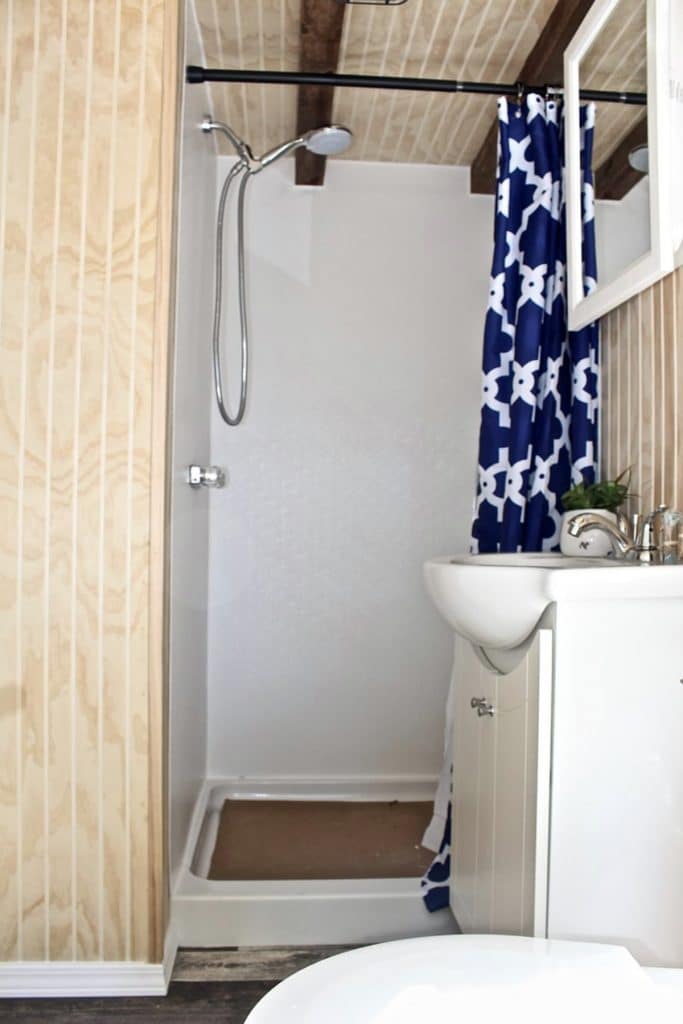 Shower stall with blue and white curtain