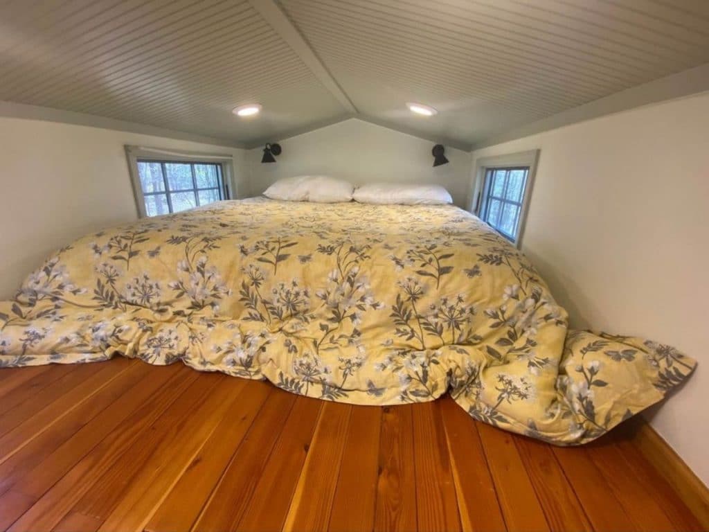 Bed in loft with windows on both sides