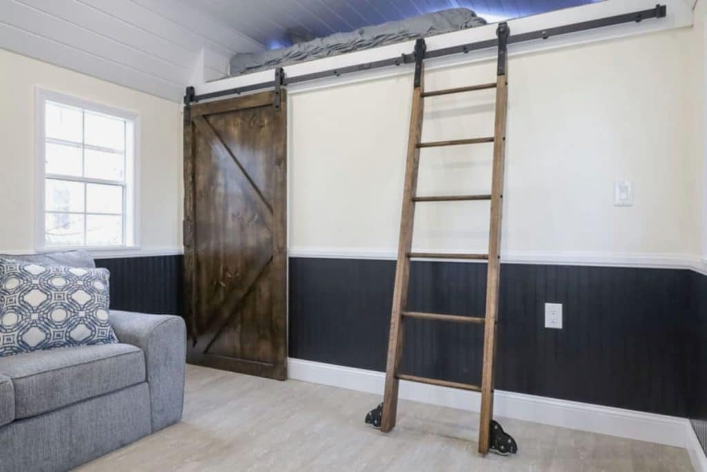 Barn door against wall with ladder going to loft