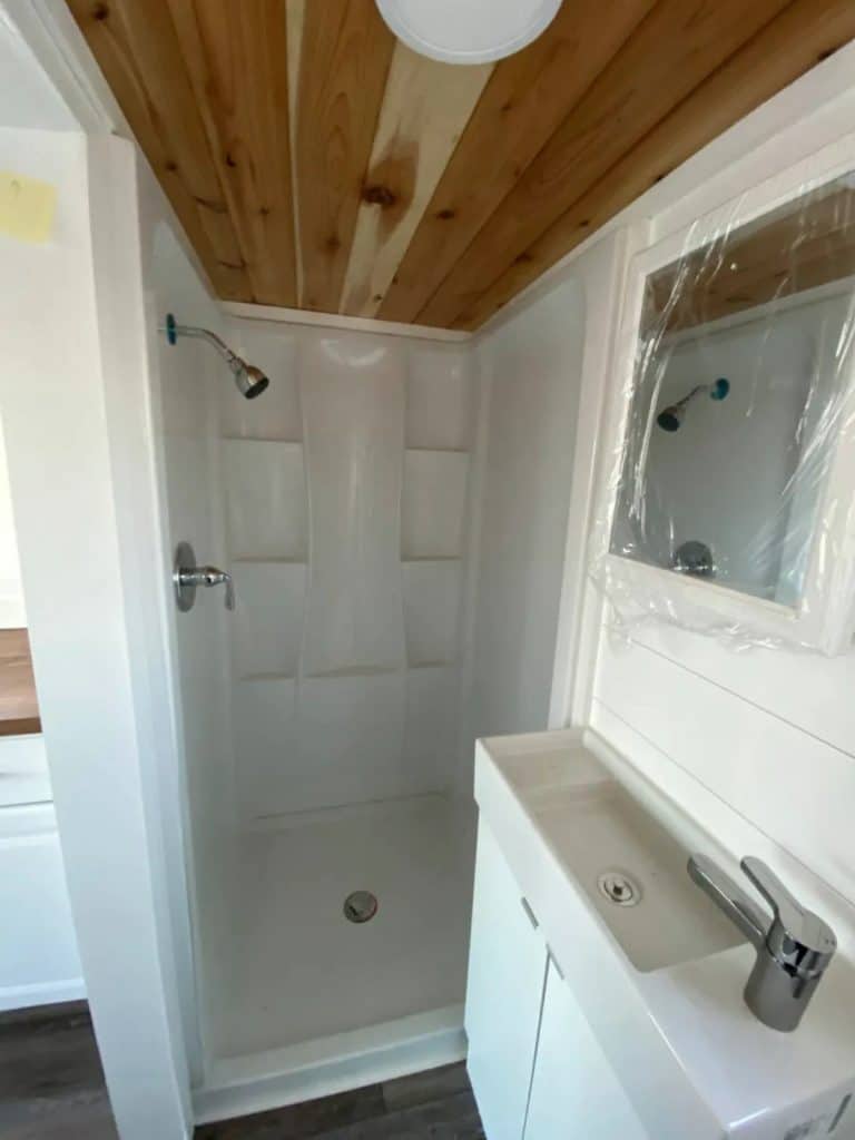 White shower stall with wooden ceiling