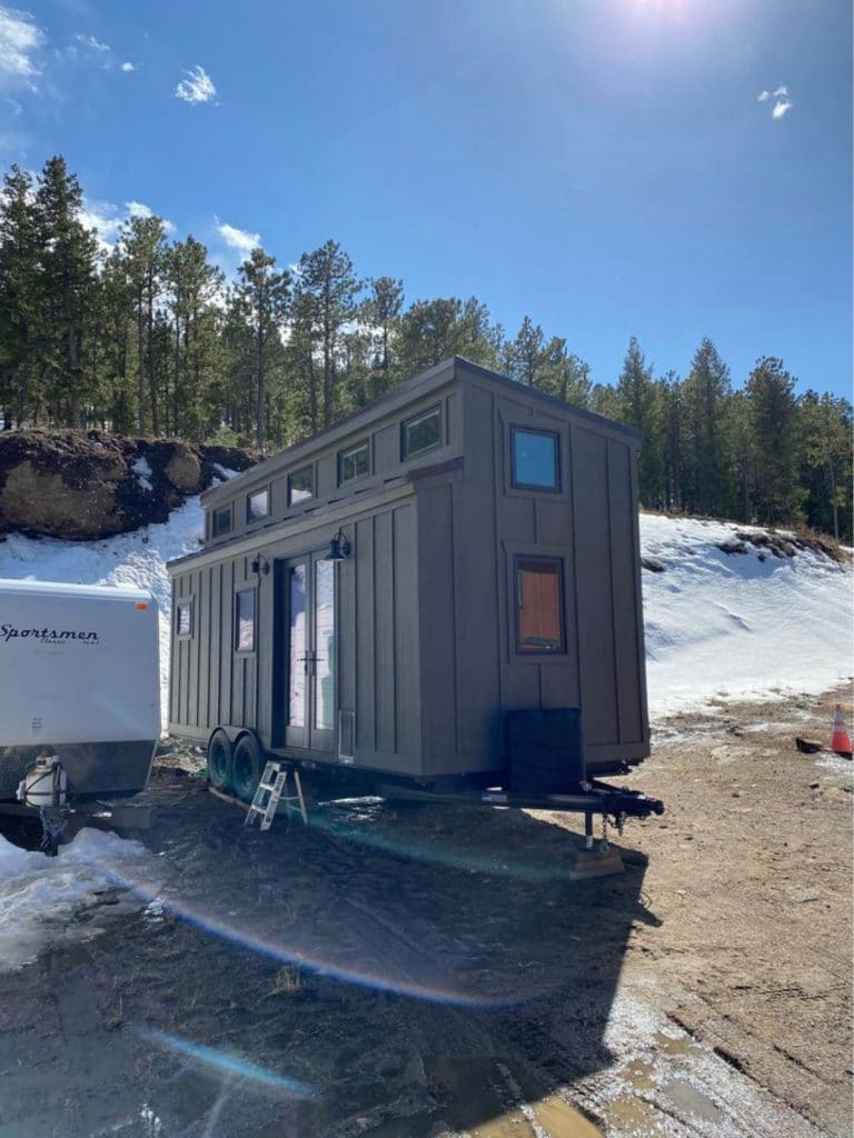 Gray tiny home parked by snow bank