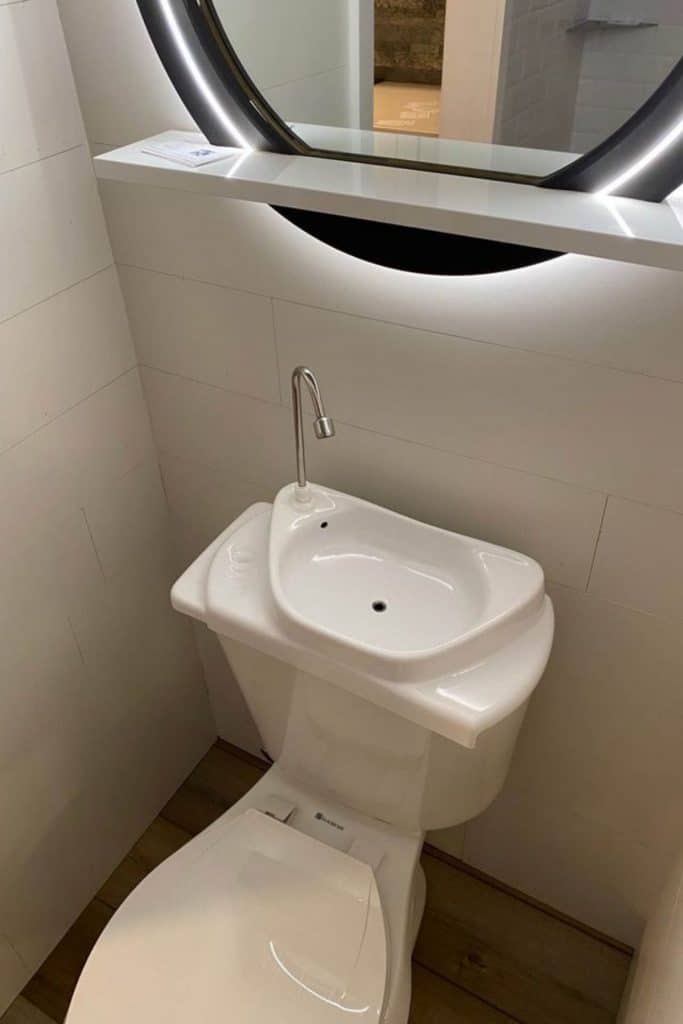 Close up image of toilet with sink attached to tank