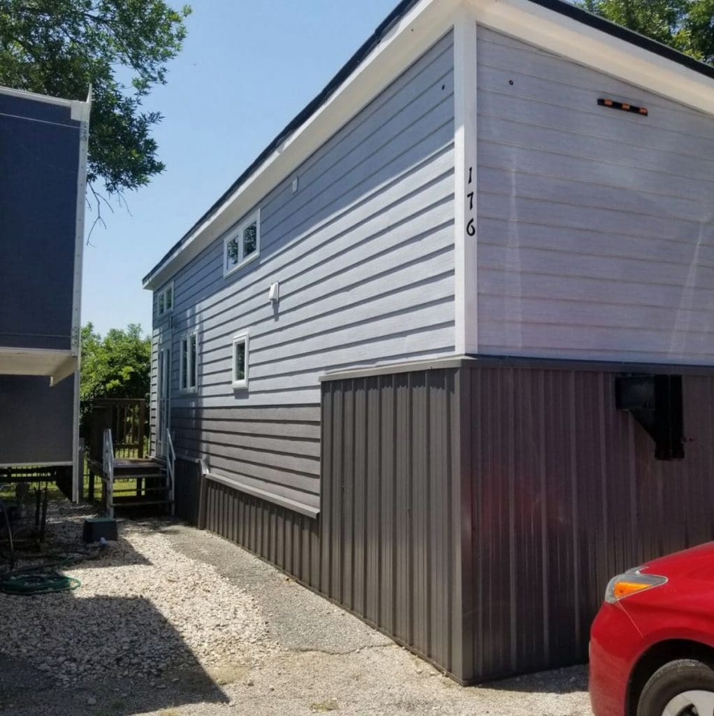 Outside of tiny house with gray and light blue siding