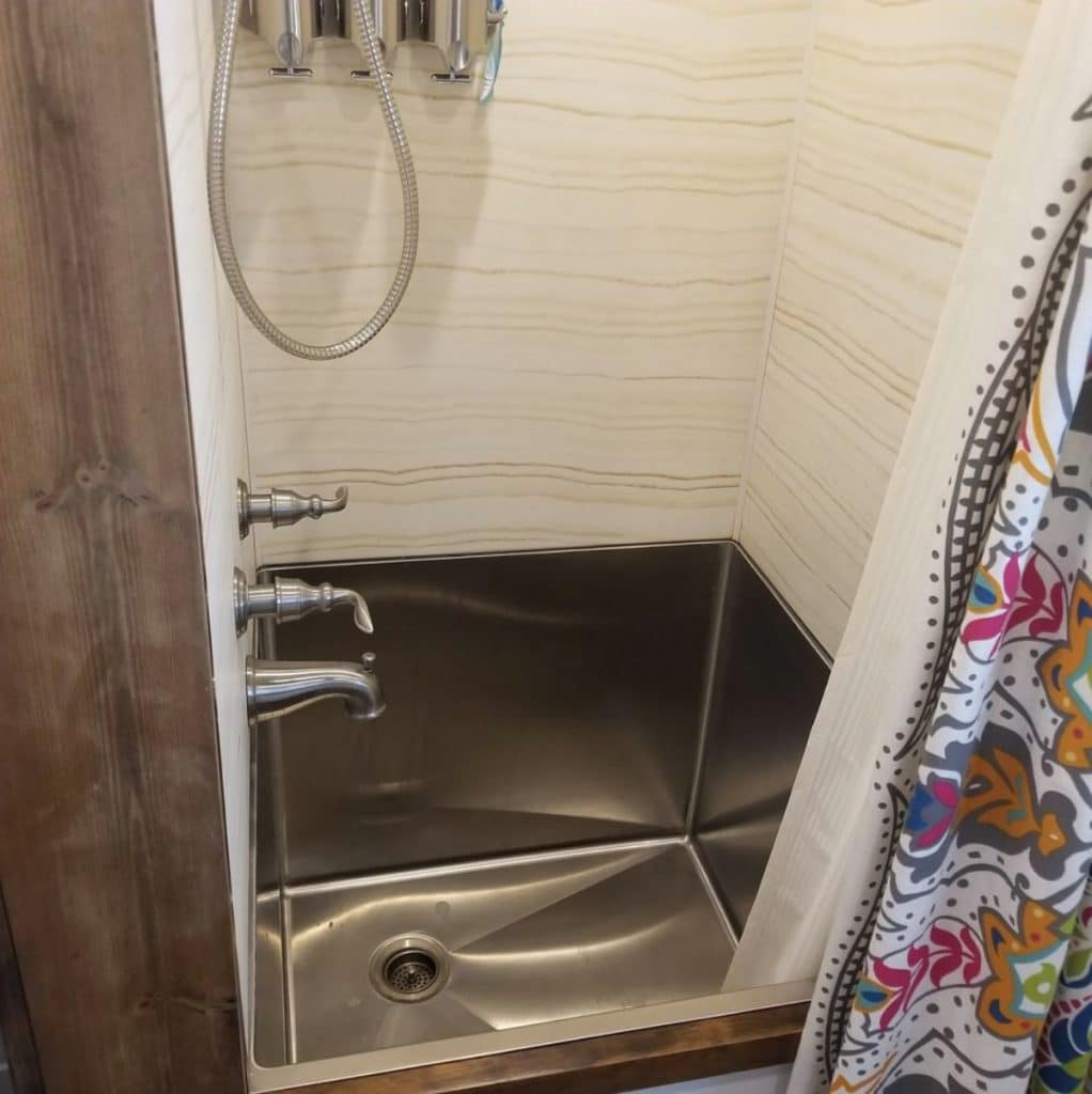 Stainless steel base of shower with shiplap wall