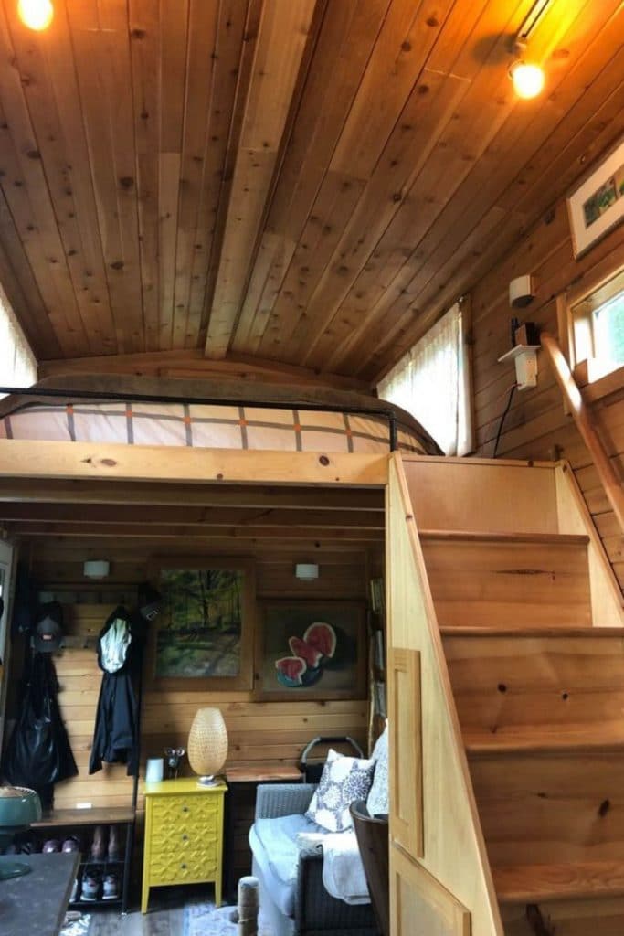 Woodgrain paneling and stairs to loft