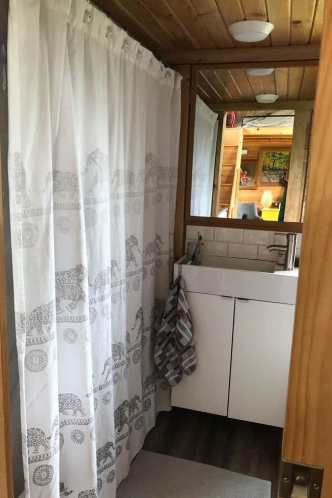 White shower curtain in bathroom with white vanity