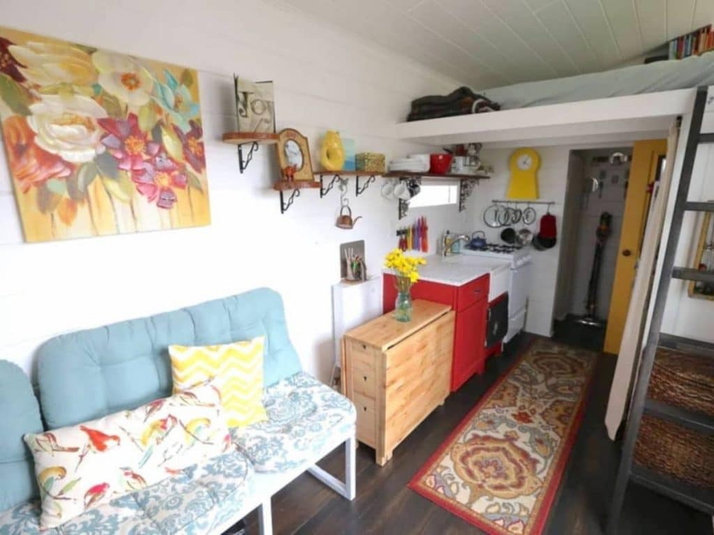 View into kitchen of tiny home with blue sofa