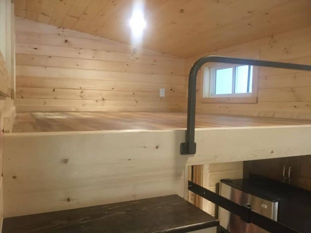 View from stairs into loft with natural wood surrounding walls and ceiling