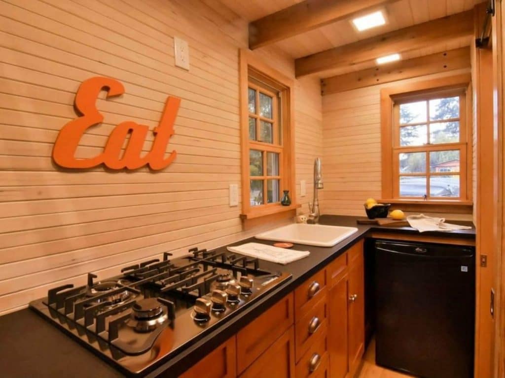 Eat signabove gas cooktop on counter with white sink