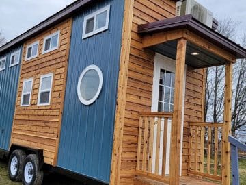 Light wood and blue siding on tiny house with small front porch