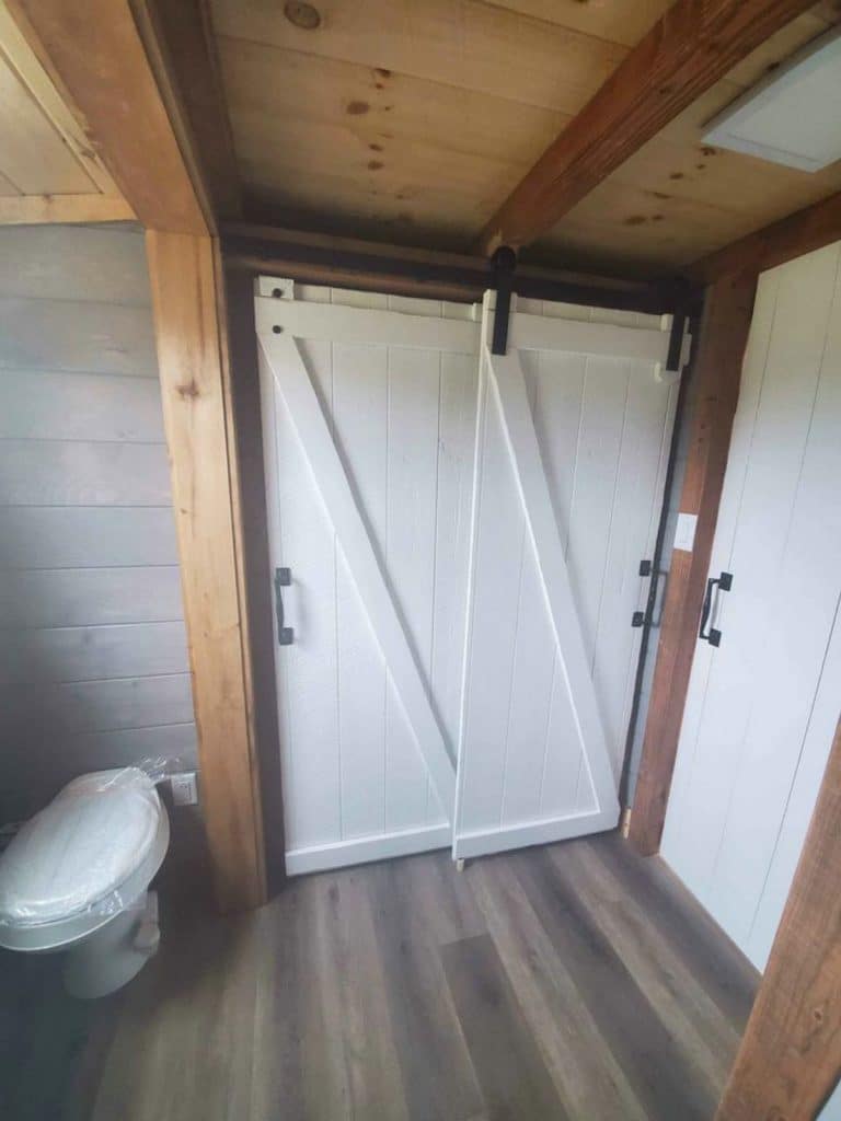 White barn doors in bathroom with compost toilet