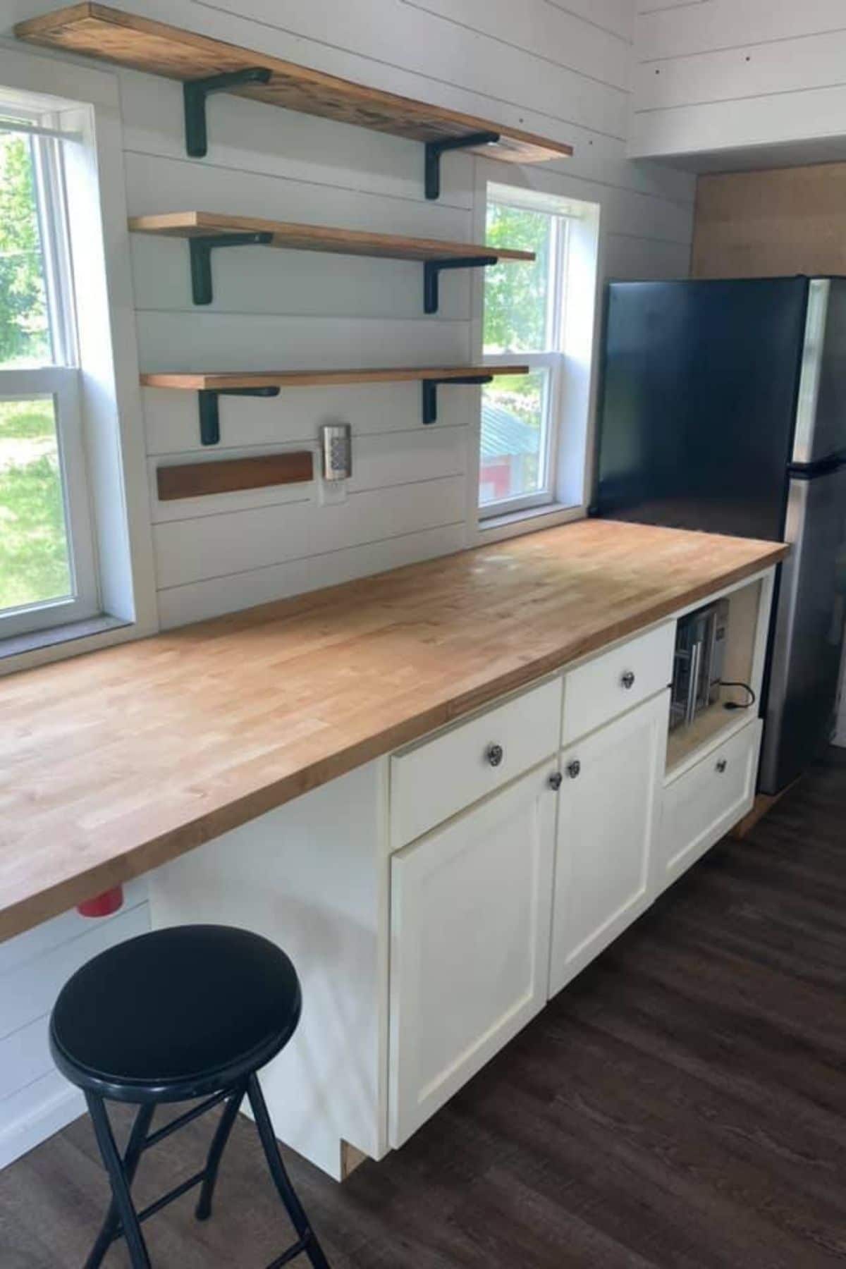 Kitchen counter with stool under open space and floating shelves