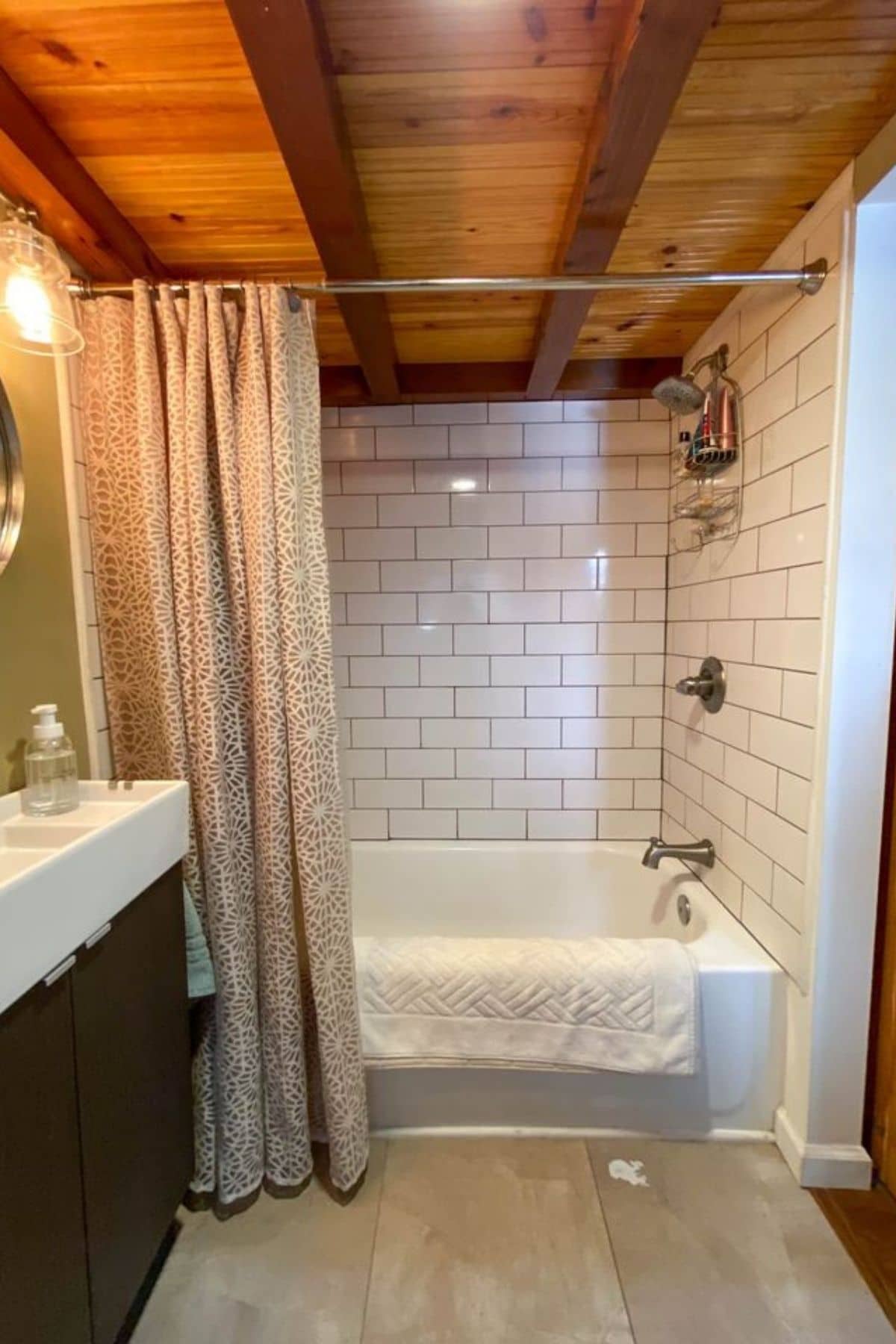 Bathtub shower with subway tile and tan curtain