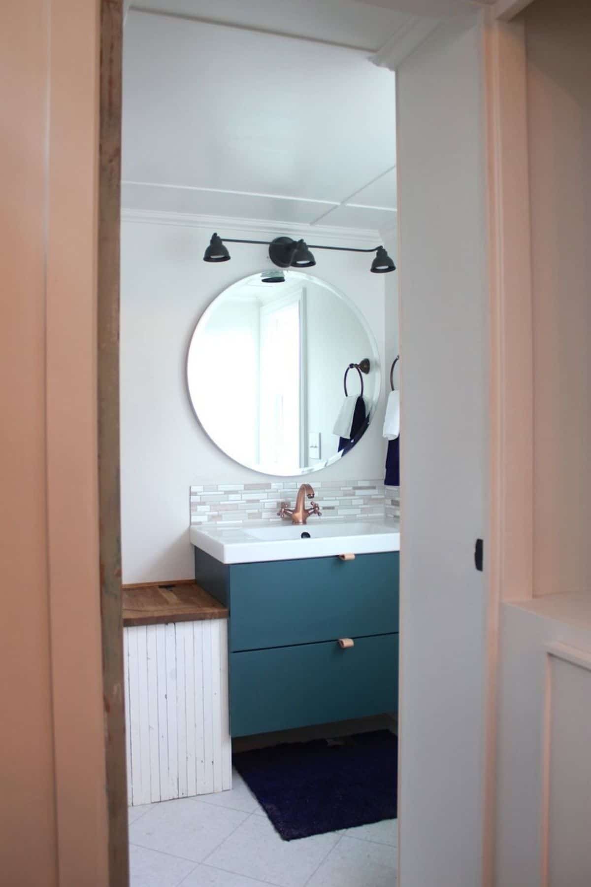 View into bathroom from door with teal vanity