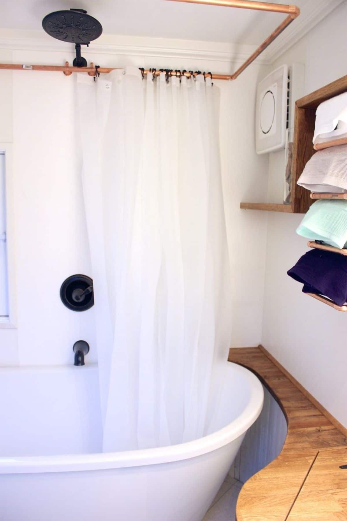 White clawfoot bathtub with shower curtain pulled