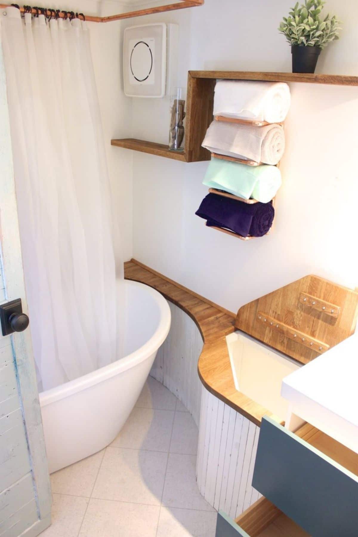 Bathtub next to bench with wooden top