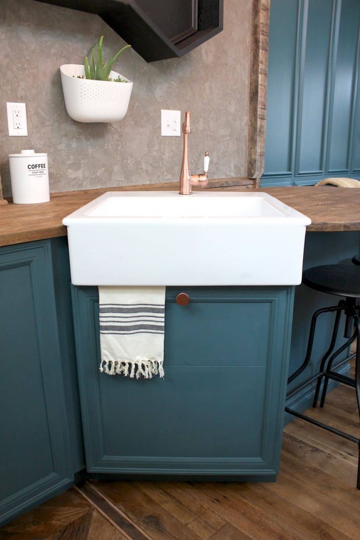 Teal cabinets under white farmhouse sink