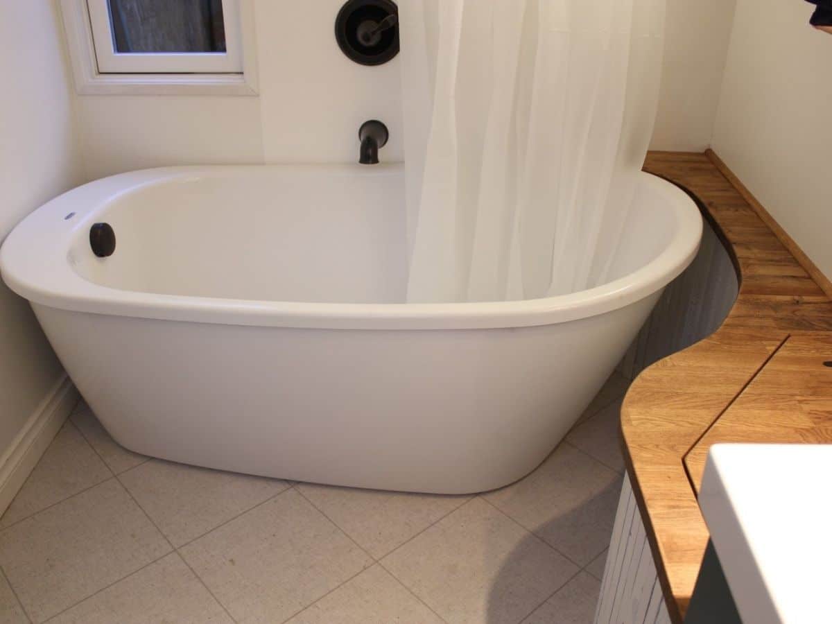 Large white soaking tub in bathroom
