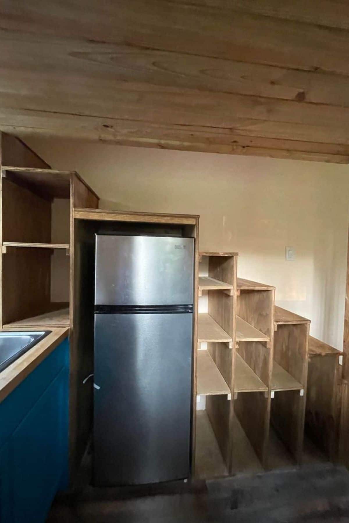 Stainless steel refrigerator under stairs to loft