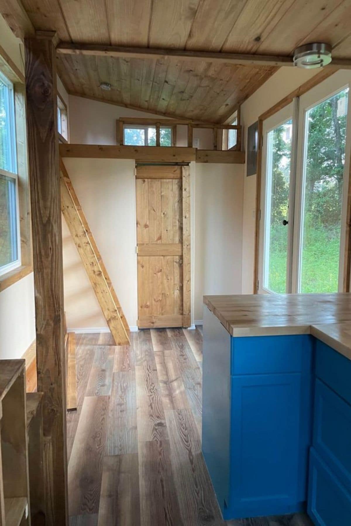 View from kitchen to bathroom pocket door with small loft above