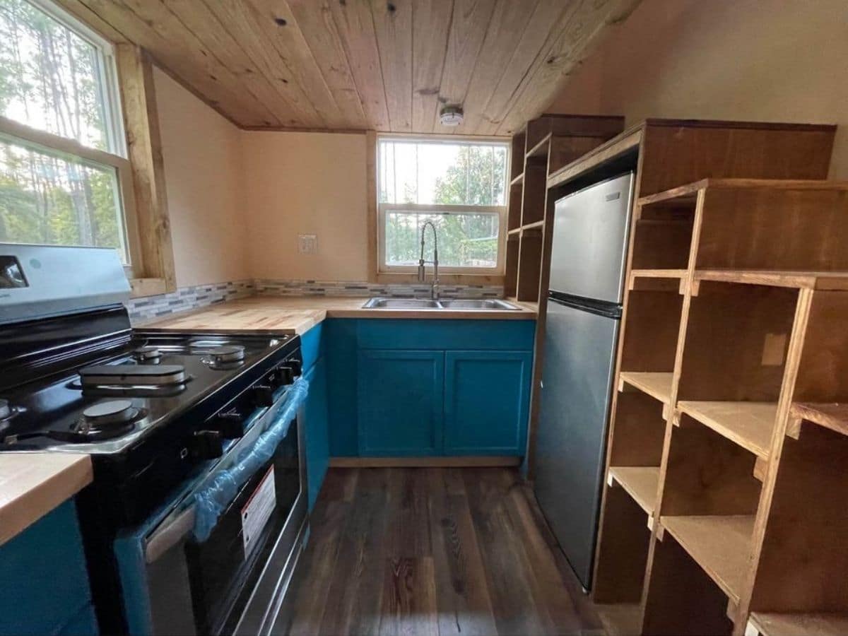 View into kitchen with bright blue cabinets under butcher block counter