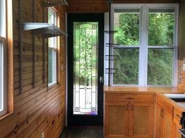 View of door into tiny home with four pan window to the right