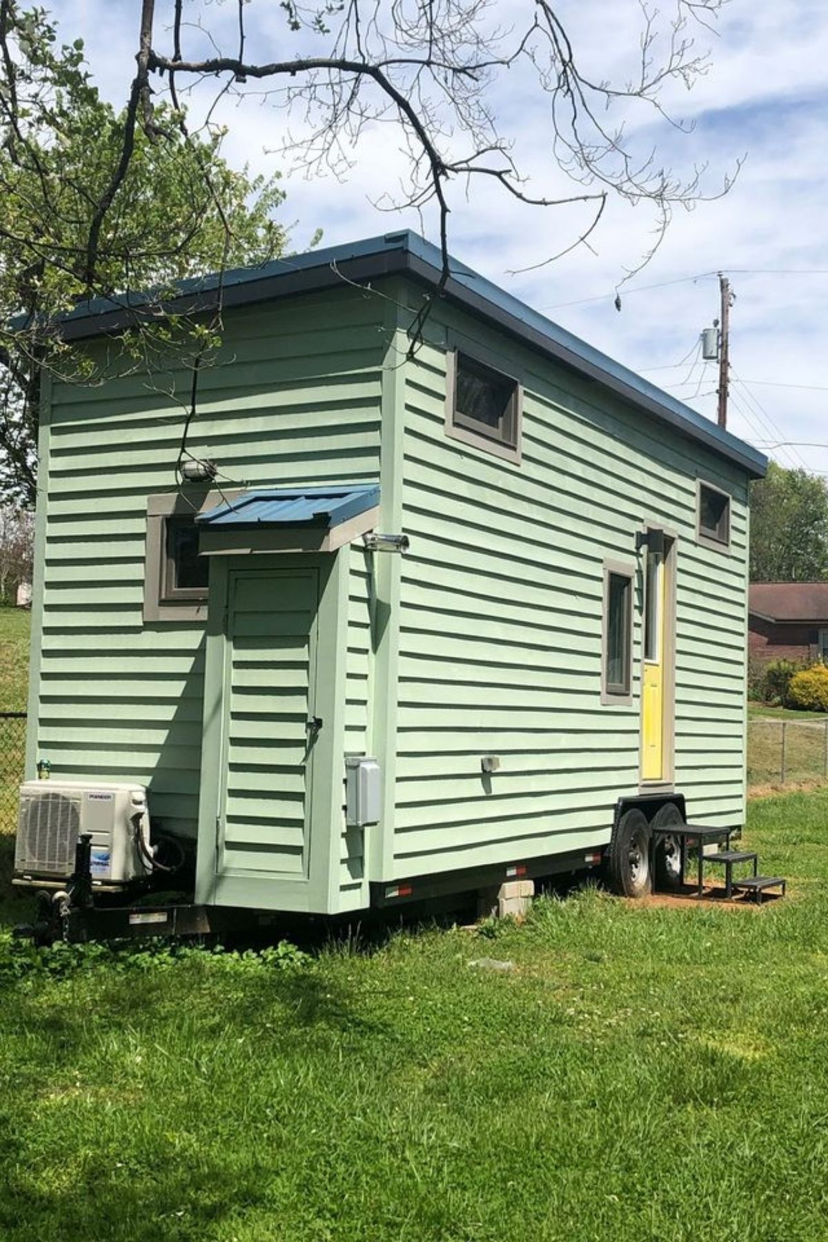 Back side of tiny house with light green siding