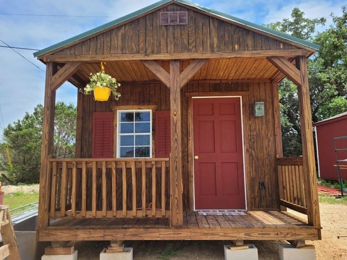 Front of cabin with red door and small porch