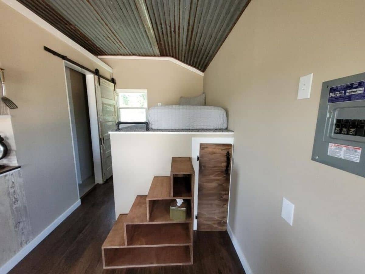Wood stairs to platform bed with small door beneath
