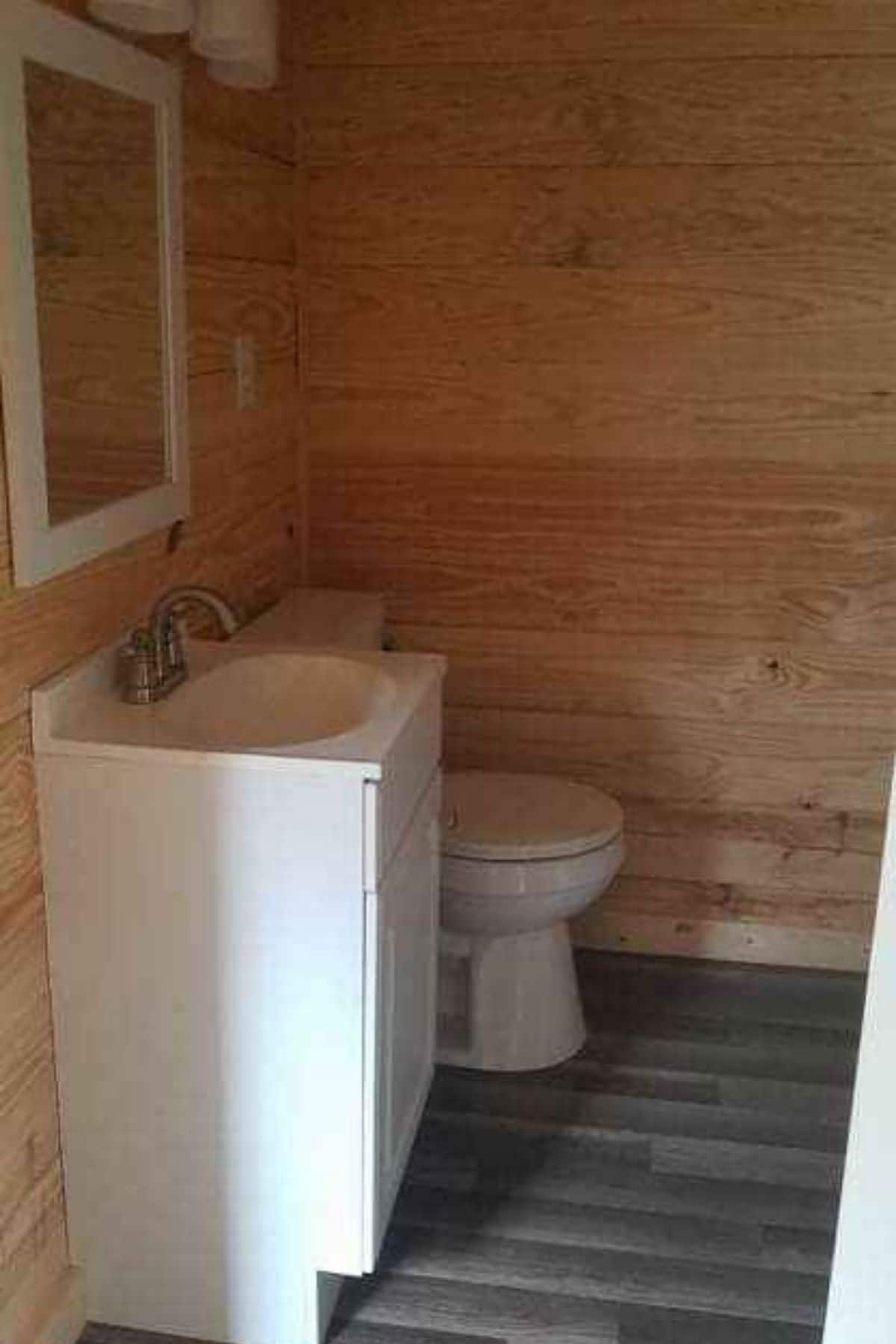 View into bathroom with vanity and toilet from door