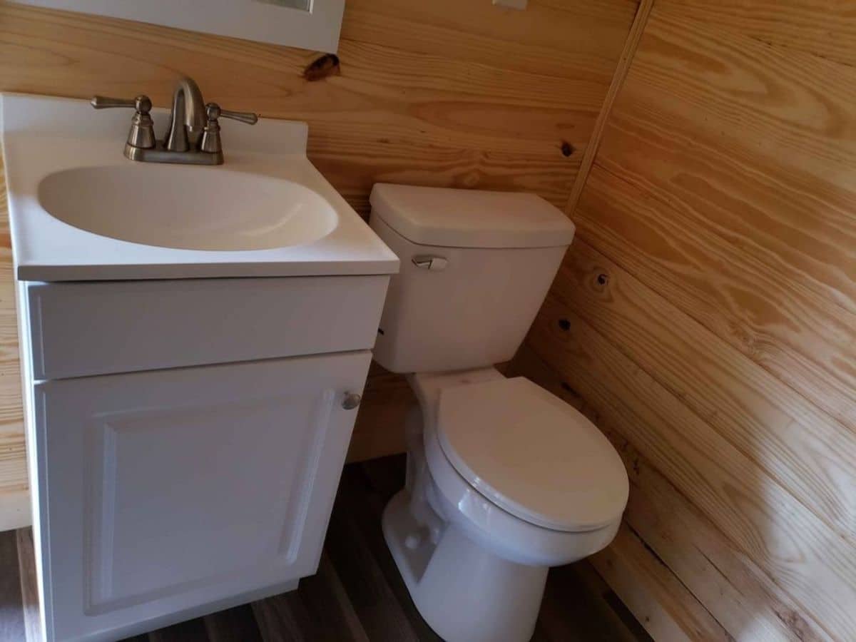 Traditional toilet with small white sink in bathroom